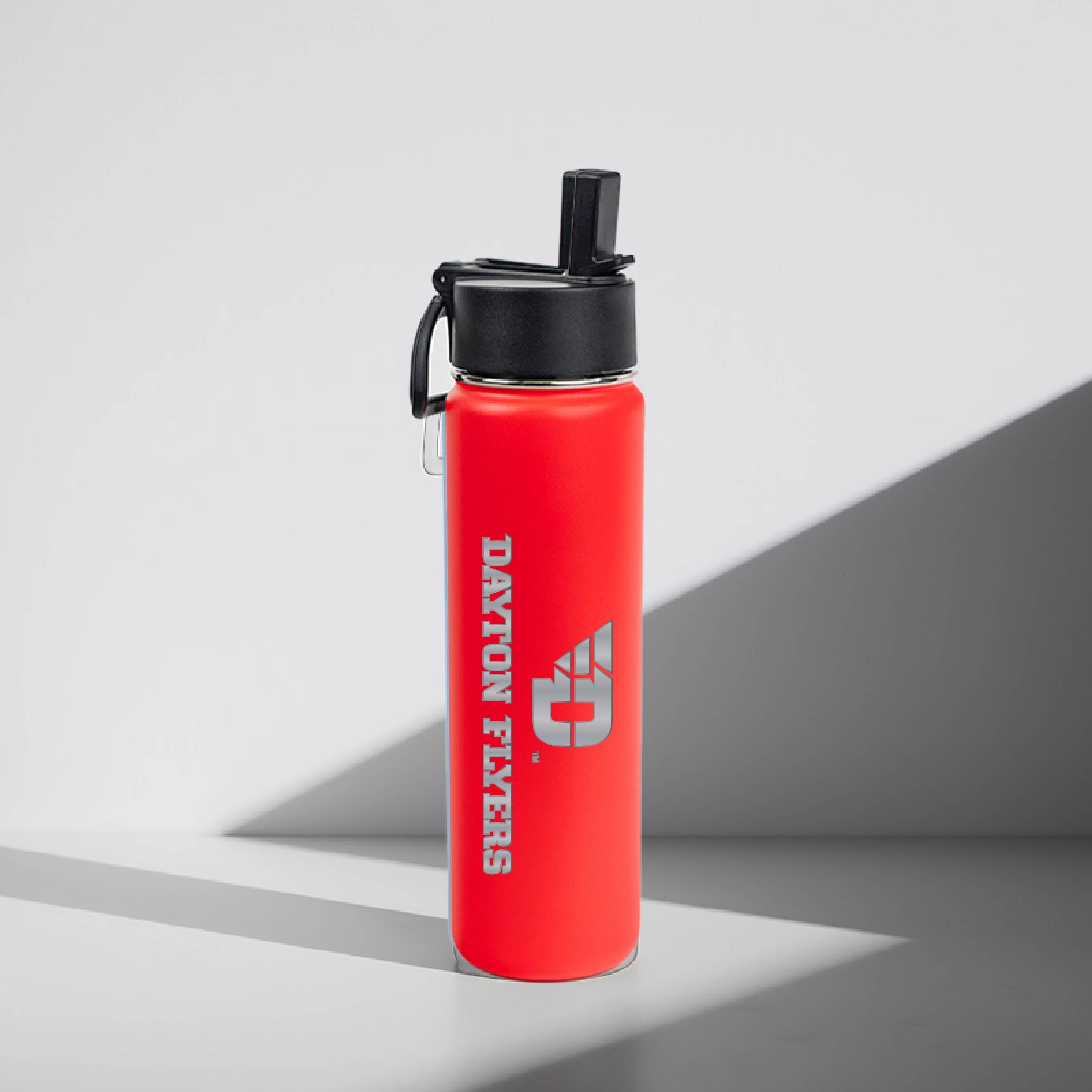 Red water bottle with black lid on a gray background