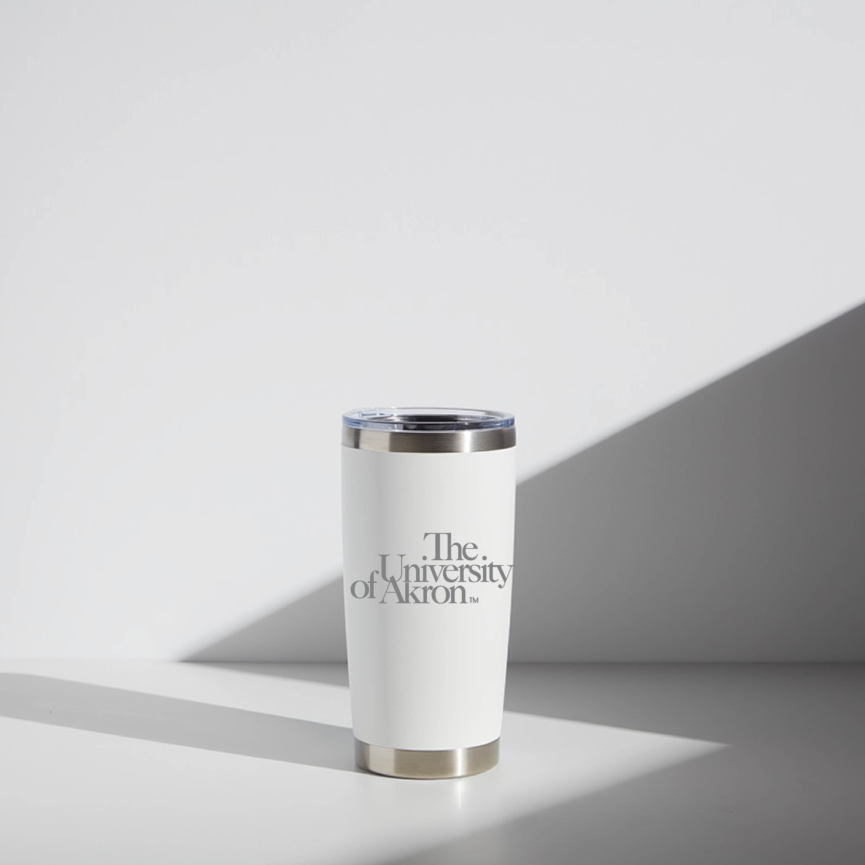 Alt text: "20 oz WATR Tumbler featuring University of Akron branding on a cream-white body with a stainless steel rim and base, placed against a light background with subtle shadowing."