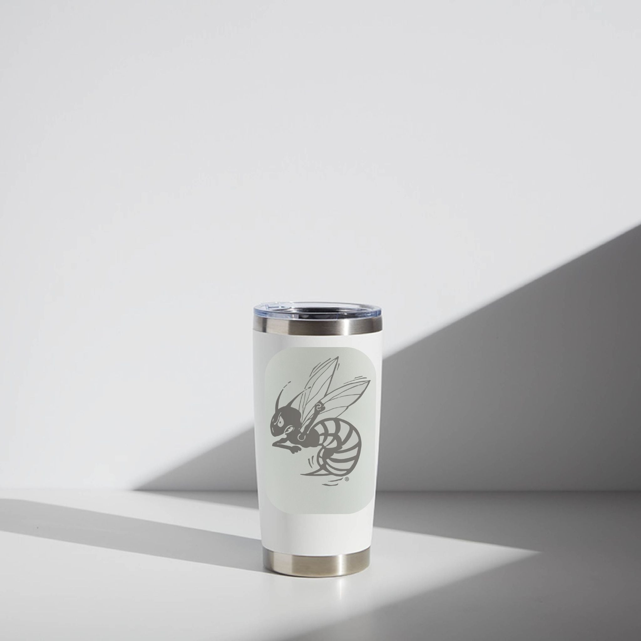 White tumbler with a bee design on a light gray background