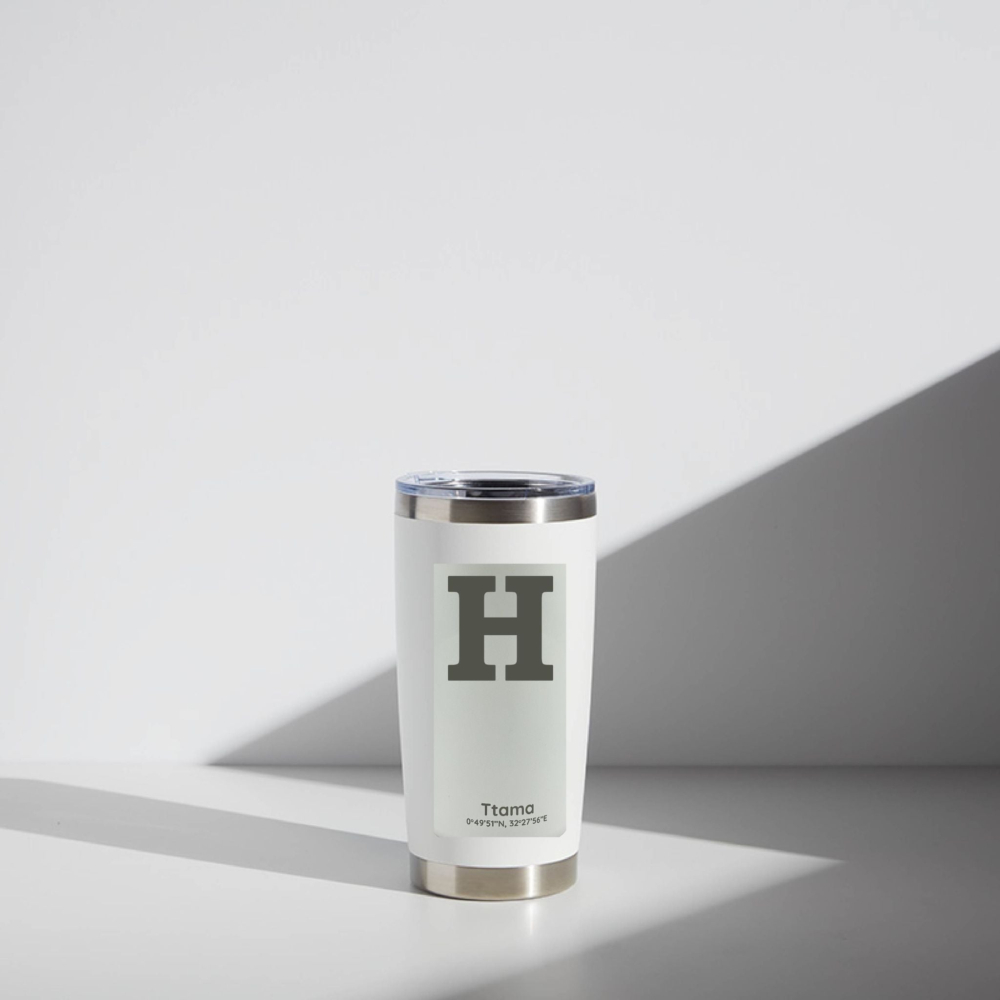 White tumbler with a logo on a light gray background